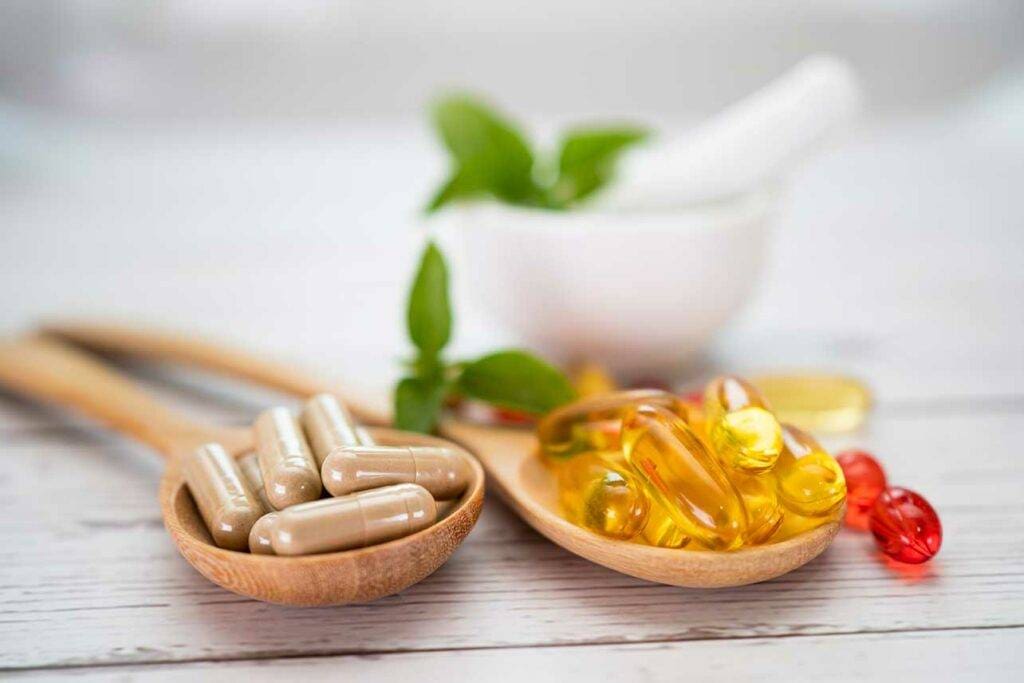 Vitamin C Pills And Vitamin E Omega 3 Fish Oil On Wooden Spoon For Good Health